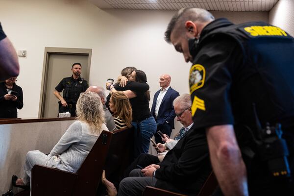 Supporters of former Grand Rapids Police officer Christopher Schurr hug after Judge Christina Mims declared a mistrial at the Kent County Courthouse in Grand Rapids, Mich., Thursday, May 8, 2025. (Joel Bissell/MLive.com/Kalamazoo Gazette via AP)