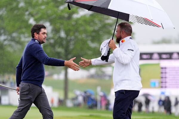 Keegan Bradley, left, and Shane Lowry, of Ireland, shake hands after the second round of the Truist Championship golf tournament at the Philadelphia Cricket Club, Friday, May 9, 2025, in Flourtown. (AP Photo/Matt Rourke)