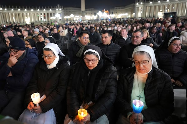 People attend a rosary prayer with Cardinal Victor Manuel Fernandez held for the health of Pope Francis in St Peter's Square at The Vatican, Friday, Feb. 28, 2025. (AP Photo/Kirsty Wigglesworth)