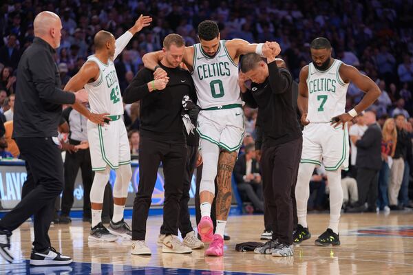 Trainers help Boston Celtics' Jayson Tatum (0) off the court after he was injured during the second half of Game 4 in the Eastern Conference semifinals of the NBA basketball playoffs against the New York Knicks Monday, May 12, 2025, in New York. (AP Photo/Frank Franklin II)