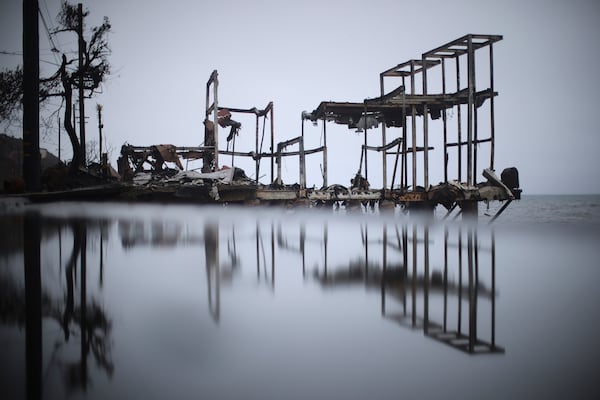 Water is reflected on the ground under a burned beachfront property in the Palisades Fire zone during a storm Thursday, Feb. 13, 2025, in Malibu, Calif. (AP Photo/Ethan Swope)