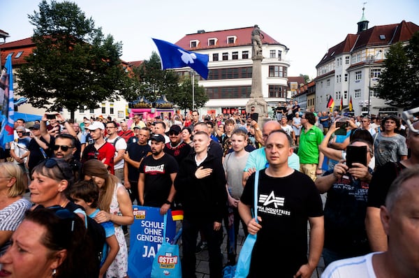 FILE - Supporters of the far-right Alternative for Germany party, AfD, sing the national anthem as they attend an election campaign rally of the party for the upcoming state elections in Suhl, Germany, Aug. 13, 2024. (AP Photo/Markus Schreiber, File)