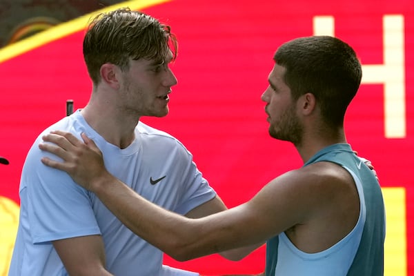 Carlos Alcaraz, right, of Spain is congratulated by Jack Draper of Britain, left after Draper retires from their fourth round match at the Australian Open tennis championship in Melbourne, Australia, Sunday, Jan. 19, 2025. (AP Photo/Mark Baker)