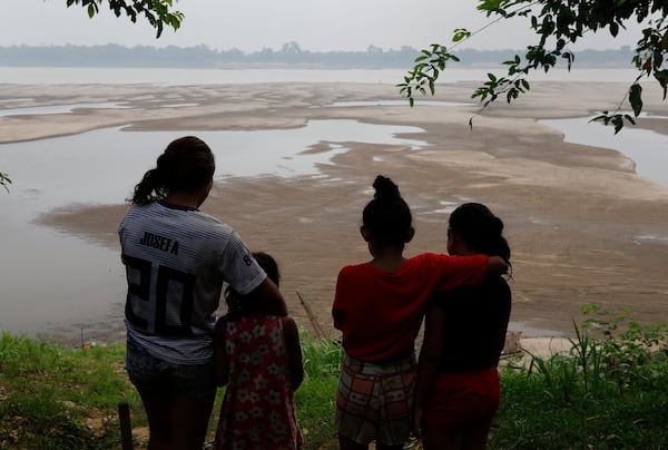 FILE - Residents look out at the Madeira River, a tributary of the Amazon River amid a drought in Humaita, Amazonas state, Brazil, Sept. 7, 2024. (AP Photo/Edmar Barros, File)