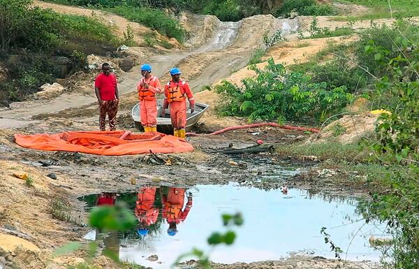 FILE - In this frame from video, workers stand by a container to collect oil spill waste from a Shell facility in Ogoniland, Nigeria, June 16, 2023. (AP Photo, File)