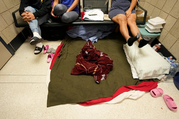 FILE - Migrants from Venezuela take shelter in the Chicago Police Department's 16th District station, May 1, 2023. (AP Photo/Charles Rex Arbogast, File)