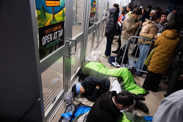 From front, shareholders Haibo Liu, Liyang Jiang and Cheng Guo of China rest in sleeping bags outside CHI Health Center Omaha for the Berkshire Hathaway annual meeting Saturday, May 3, 2025, in Omaha, Neb. The group arrived at 11 p.m. the night before to retain a spot at the front of the line. (AP Photo/Rebecca S. Gratz)