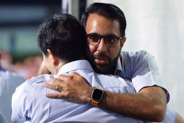 Singapore opposition leader and Workers' Party (WP) Secretary-General, Pritam Singh shares a hug with party member, Jamus Lim at the assembly centre during the general election in Singapore, Saturday, May 3, 2025. (AP Photo/Suhaimi Abdullah)
