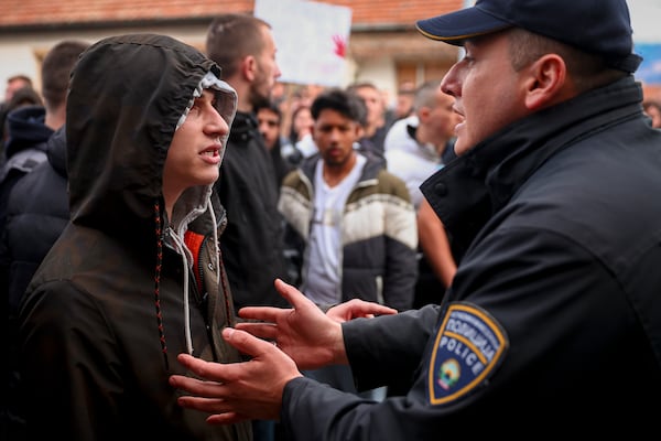 People argue with policemen, outside the home of the owner of a nightclub that was the scene of a massive fire, after a vigil for the victims in the town of Kocani, North Macedonia, Monday, March 17, 2025. (AP Photo/Armin Durgut)