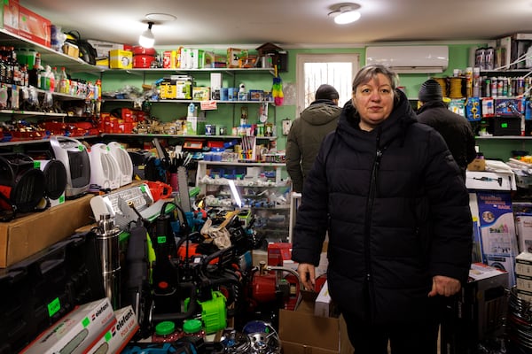 Carina Cazac, a shop owner, stands next to electrical heaters in Copanca, Moldova, Wednesday, Jan. 8, 2025. (AP Photo)