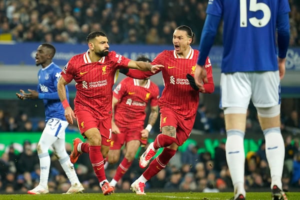 Liverpool's Mohamed Salah, centre, celebrates after scoring his side's second goal during the English Premier League soccer match between Everton and Liverpool, Liverpool, England, Wednesday, Feb.12, 2025. (AP Photo/Dave Thompson)