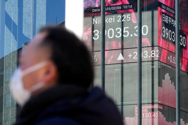 A person stands in front of an electronic stock board showing Japan's Nikkei index at a securities firm Thursday, Feb. 6, 2025, in Tokyo. (AP Photo/Eugene Hoshiko)