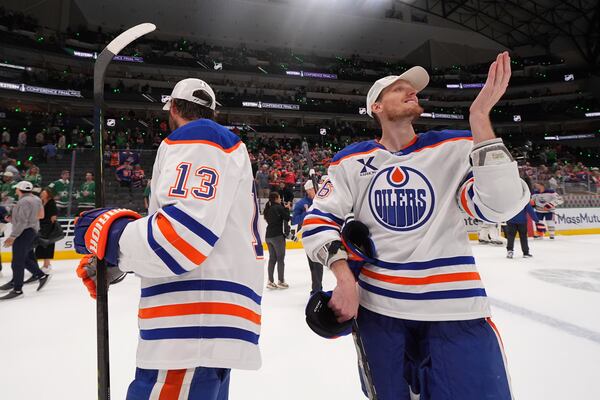 Edmonton Oilers center Mattias Janmark (13) and defenseman John Klingberg (36) celebrate after winning Game 5 of the Western Conference finals against the Dallas Stars in the NHL hockey Stanley Cup playoffs, Thursday, May 29, 2025, in Dallas. (AP Photo/Julio Cortez)