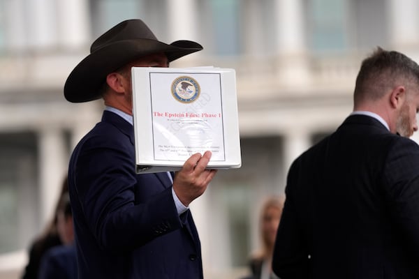 Jack Posobiec hold up a binder with a cover titled "The Epstein Files: Phase 1" at the White House, Thursday, Feb. 27, 2025, in Washington. (AP Photo/Evan Vucci)