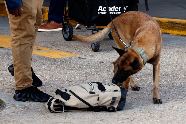 Security and bomb sniffing dogs check backpacks before entering the Superdome ahead of the Sugar Bowl NCAA College Football Playoff game, Thursday, Jan. 2, 2025, in New Orleans. (AP Photo/Butch Dill)