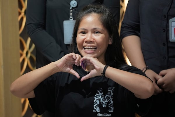 Mary Jane Veloso, a Filipina who was on death row in Indonesia and was nearly executed by firing squad in 2015, makes a heart sign during a press conference prior to her repatriation to the Philippines, at Soekarno-Hatta International Airport in Tangerang, Indonesia, Tuesday, Dec. 17, 2024. (AP Photo/Tatan Syuflana)