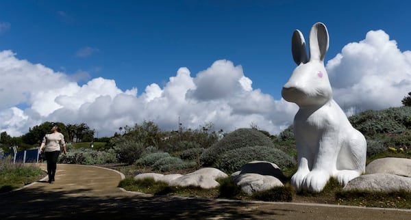 A woman walks the trails at Civic Center Park in Newport Beach, Calif., Thursday, March 13, 2025, after strong storms moved through the region overnight. (Paul Bersebach/The Orange County Register via AP)