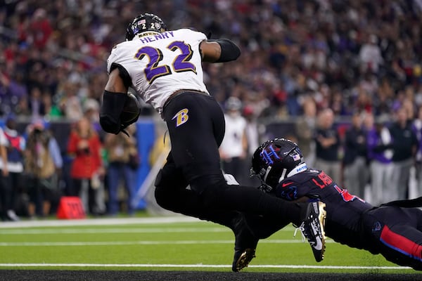 Baltimore Ravens running back Derrick Henry (22) is tackled by Houston Texans cornerback Kamari Lassiter, right, for a safety during the first half of an NFL football game, Wednesday, Dec. 25, 2024, in Houston. (AP Photo/Eric Christian Smith)