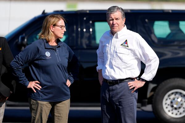 FILE- North Carolina Gov. Roy Cooper, right, and Deanne Criswell, Administrator of the U.S. Federal Emergency Management Agency, await the arrival of Democratic presidential nominee Vice President Kamala Harris for a briefing on the damage from Hurricane Helene, at Charlotte Douglas International Airport, in Charlotte, N.C., Oct. 5, 2024. (AP Photo/Chris Carlson, File)