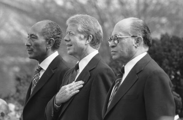 FILE - Egyptian President Anwar Sadat, left, U.S. President Jimmy Carter, center, and Israeli Prime Minister Menachem Begin, stand at attention as the national anthems of their respective countries are played on the north lawn of the White House in Washington, on Feb. 24, 1979. (AP Photo, File)