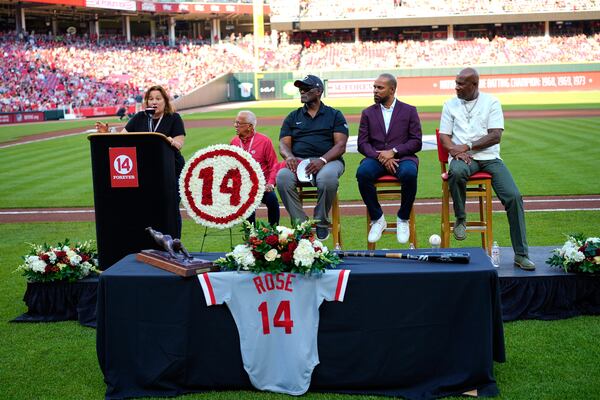 Pete Rose's daughter Fawn Rose speaks as Reds Hall of Fame players, left to right, George Foster, Barry Larkin and Eric Davis listen during Pete Rose Night events before a baseball game between the Cincinnati Reds and the Chicago White Sox, Wednesday, May 14, 2025, in Cincinnati. (AP Photo/Carolyn Kaster)