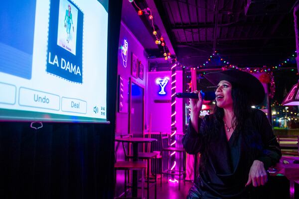 Audrey Campos announces the Loteria card La Dama during a Loteria game night at Jackie O's Cocktail Club in Fort Worth, Texas, Tuesday, May 27, 2025. (AP Photo/Ronaldo Bolaños)