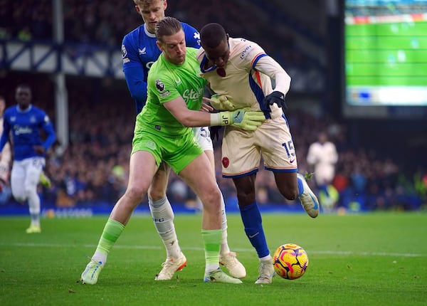 Everton goalkeeper Jordan Pickford and Chelsea's Nicolas Jackson (right) battle for the ball during the English Premier League match soccer match between Everton and Chelsea, at Goodison Park, Liverpool, England, Sunday Dec. 22, 2024. (Peter Byrne/PA via AP)