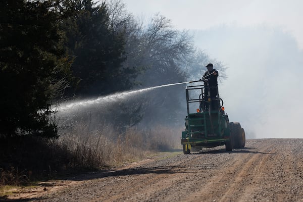 Fire crews and volunteers battle hot spots and new fires 8 miles west of Stillwater, Okla. on Monday, March 17, 2025. (AP Photo/Alonzo Adams)