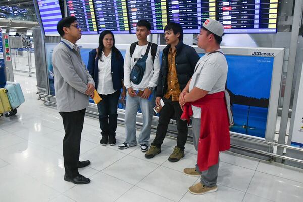 In this photo provided by the Thai Foreign Ministry, an official, left, from the Department of Consular Affairs, talks to family members of released Thai hostages freed from Hamas, before they travel to Tel Aviv, Israel, from the Suvarnabhumi International Airport in Samut Prakarn Province, Thailand, Monday, Feb. 3, 2025. (Thai Foreign Ministry via AP)