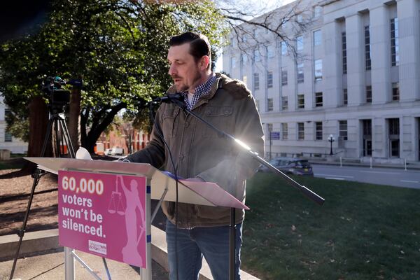 Ted Corcoran reads names from a list of over 60,000 people who cast ballots in the November 2024 election but whose votes have been challenged by Republican state Supreme Court candidate Jefferson Griffin in his extremely close race with Demcoratic Associate Justice Allison Riggs, Tuesday, Jan. 14, 2025, in Raleigh, N.C. Behind him is the North Carolina Supreme Court. (AP Photo/Chris Seward)