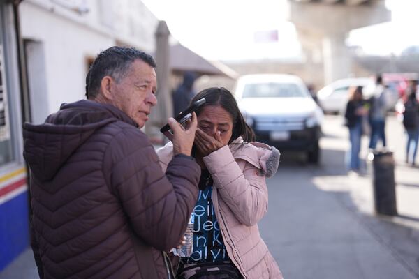 Marcela Medina and her husband Enrique Corea of Venezuela react to seeing that their appointment was canceled on the U.S. Customs and Border Protection (CBP) One app, as they wait near the border crossing in Tijuana, Mexico on Monday, Jan. 20. 2025. (AP Photo/Gregory Bull)