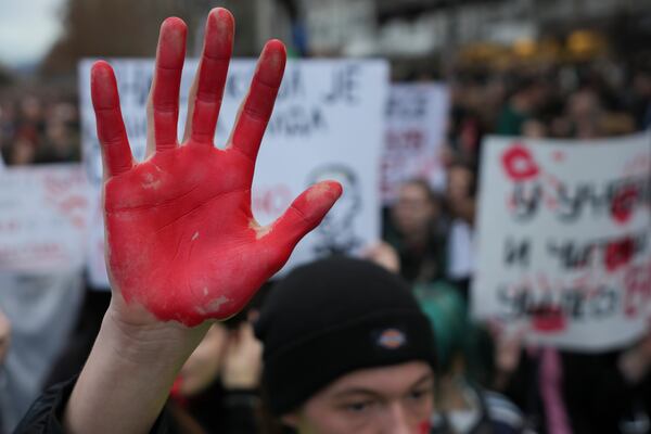 A man raises a red hand symbolizing the blood during a protest, a day after the assault on students was carried out by thugs with baseball bats, in Novi Sad, Serbia, Tuesday, Jan. 28, 2025. (AP Photo/Darko Vojinovic)