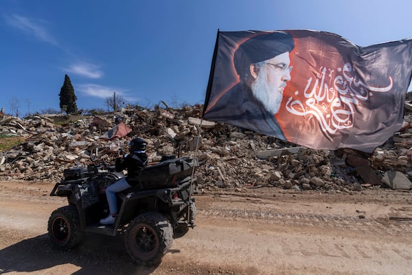 Lebanese citizens check the destruction in their village caused by the Israeli air and ground offensive, in the town of Kfar Kila, southern Lebanon, Tuesday, Feb. 18, 2025. (AP Photo/Hassan Ammar)