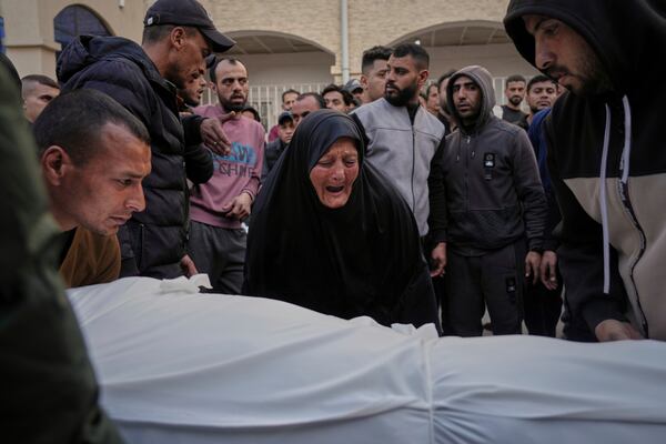 A woman reacts over the body of a person killed during overnight Israeli army airstrikes across the Gaza Strip, at the Al-Ahli hospital in Gaza City, Tuesday, March 18, 2025. (AP Photo/Jehad Alshrafi)