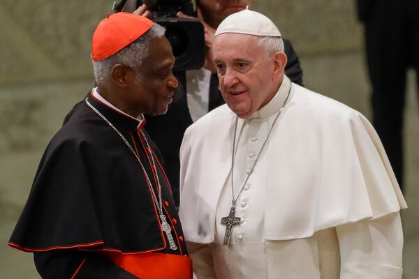 FILE - Pope Francis talks with Cardinal Peter Kodwo Appiah Turkson during his weekly general audience, in Paul VI Hall at the Vatican, Wednesday, Jan. 15, 2020. (AP Photo/Alessandra Tarantino, File)