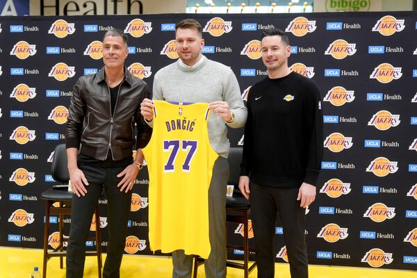 From left to right, Los Angeles Lakers general manager Rob Pelinka, Luka Doncic, and head coach JJ Redick pose for photos during an introductory NBA basketball press conference Tuesday, Feb. 4, 2025, in El Segundo, Calif. (AP Photo/Jae C. Hong)