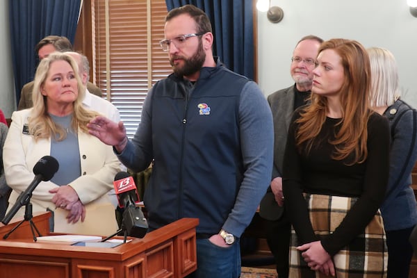 John Cantrell, of Topeka, Kan., answers questions from reporters about a potential threat to a landmark disability rights law from a lawsuit filed by Republican state attorneys general, Monday, Feb. 17, 2025, at the Statehouse in Topeka. Listening to him speak are, from left to right, Rep. Mari-Lynn Poskin, D-Leawood, and his wife, Tayler. (AP Photo/John Hanna)