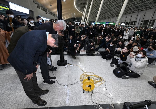 Jeju Air CEO Kim E-bae , left, and other executive members bow in apology to relatives of passengers at the Muan International Airport in Muan, South Korea, Sunday, Dec. 29, 2024. (Lee Jin-wook/Yonhap via AP)