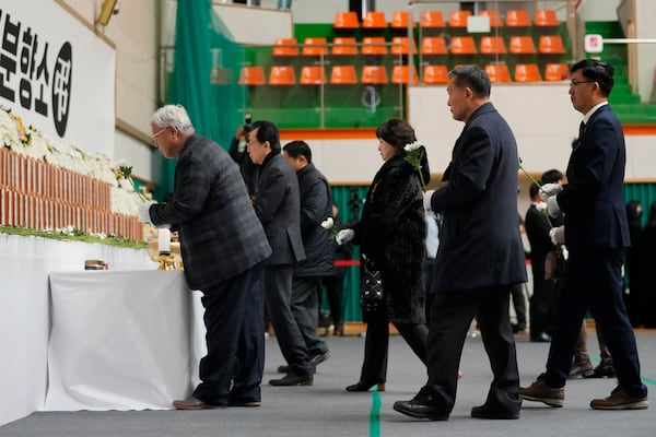 Mourners place flowers for the victims of a plane fire at a memorial altar at Muan sport park in Muan, South Korea, Monday, Dec. 30, 2024. (AP Photo/Ahn Young-joon)