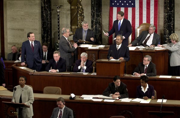 FILE - Rep. Cynthia McKinney, D-Ga., lower left, objects to Florida's electoral vote count results, as Vice President Al Gore, standing, top center, and House Speaker Dennis Hastert, R-Ill., seated, top right, listen on the floor of the U.S. House of Representatives, in Washington, Jan. 6, 2001. Other members present, seated at left in middle row are: Sen. Mitch McConnell, R-Ky., Chris Dodd, D-Ct, hand over mouth., Chaka Fattah, D-Pa., standing at podium and Rep. William Thomas, R-Calif. Others not identified. (AP Photo/Kenneth Lambert, File)