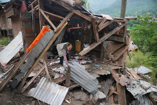 A person inspects his damaged shop following overnight shelling from Pakistan at Gingal village in Uri district, Indian controlled Kashmir, Friday, May 9, 2025. (AP Photo/Dar Yasin)