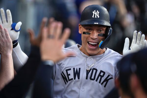 New York Yankees' Aaron Judge is congratulated by teammates in the dugout after hitting a solo home run during the first inning of a baseball game against the Los Angeles Dodgers, Friday, May 30, 2025, in Los Angeles. (AP Photo/Mark J. Terrill)