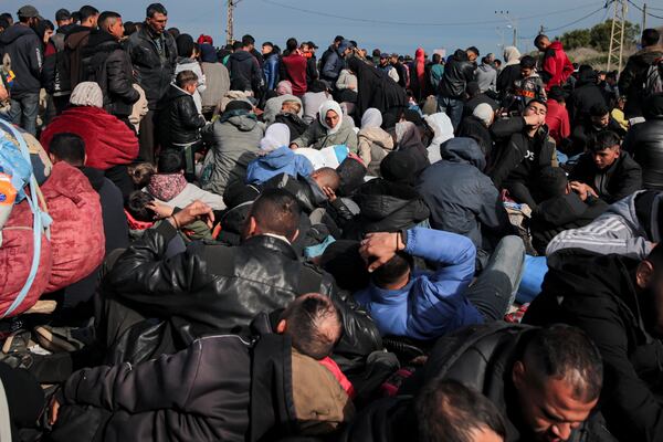 Displaced Palestinians gather with their belongings near a roadblock on the al Rashid Street, as they wait to return to their homes in the northern part of the Gaza Strip, Sunday, Jan. 26, 2025, days after the ceasefire deal between Israel and Hamas came into effect. (AP Photo/Jehad Alshrafi)