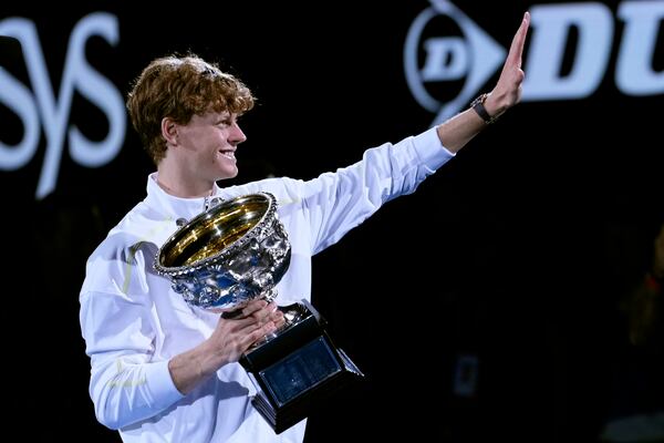 Jannik Sinner of Italy waves as he carries the Norman Brookes Challenge Cup after defeating Alexander Zverev of Germany in the men's singles final at the Australian Open tennis championship in Melbourne, Australia, Sunday, Jan. 26, 2025. (AP Photo/Ng Han Guan)