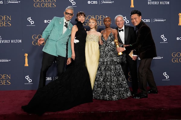 Jeff Goldblum, from left, Michelle Yeoh, Ariana Grande, Cynthia Erivo, Marc Platt, and Jon M. Chu pose with the award for cinematic and box office achievement for "Wicked" in the press room during the 82nd Golden Globes on Sunday, Jan. 5, 2025, at the Beverly Hilton in Beverly Hills, Calif. (AP Photo/Chris Pizzello)