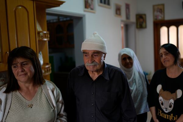 Ahmad Safadi, center, stands with his daughters after an interview about his other daughter, Sawsan, who lives inside the buffer zone near the "Alpha Line" that separates the Israeli-controlled Golan Heights from Syria, in the town of Majdal Shams, Wednesday, Dec. 18, 2024. (AP Photo/Matias Delacroix)