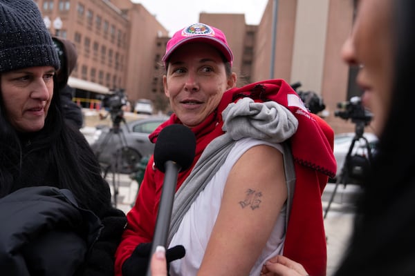 President Donald Trump supporter, Rachel Powell, who was convicted for participating in the Jan. 6 riot at the U.S. Capitol, shows her tattoo as she talks to reporters after being released from DC Central Detention Facility in Washington, Tuesday, Jan. 21, 2025. (AP Photo/Jose Luis Magana)