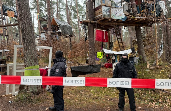 FILE - Police officers stand at the Tesla protest camp in the forest near the car factory in Grünheide, Germany, Tuesday Nov. 19, 2024. (Lutz Deckwerth/dpa via AP, File)