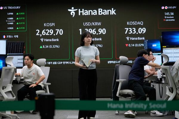 Currency traders work near a screen showing the Korea Composite Stock Price Index (KOSPI), top left, and the foreign exchange rate between U.S. dollar and South Korean won, top center, at the foreign exchange dealing room of the KEB Hana Bank headquarters in Seoul, South Korea, Friday, May 16, 2025. (AP Photo/Ahn Young-joon)