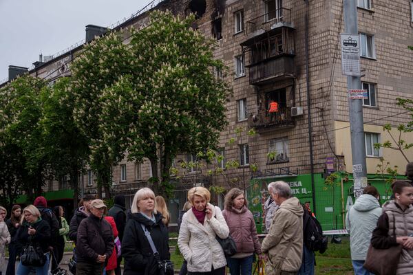 A municipal worker clear the rubble from a balcony of a residential building damaged after a Russian strike in Kyiv, Ukraine, on Wednesday, May 7, 2025. (AP Photo/Evgeniy Maloletka)